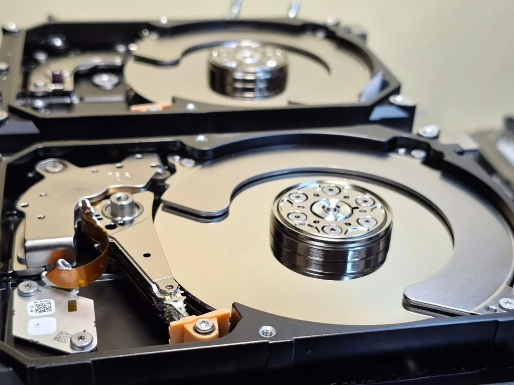 開封された2台のHDD。記録円盤と磁気ヘッドが見える内部構造